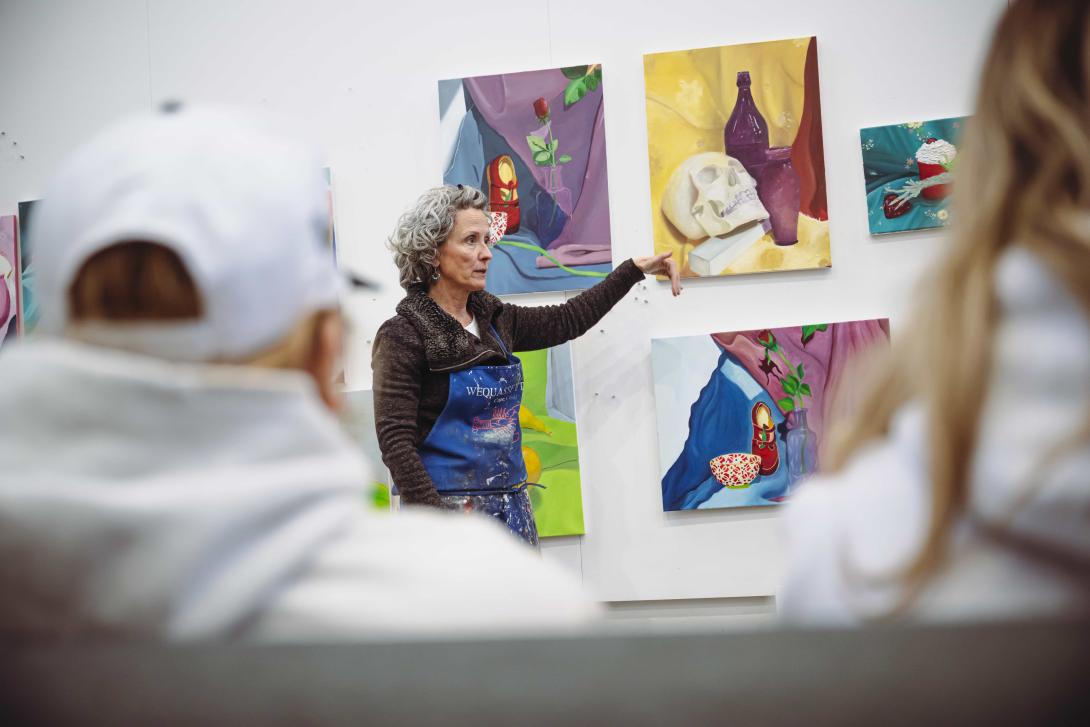 Deirdre Murphy gestures to a student painting during a critique session.